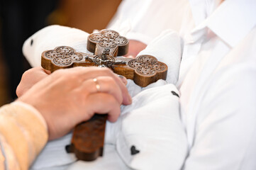 The priest placed a cross on the child, the rite of baptism of the child.