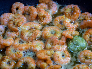 shrimps in a pan fried in olive oil and herbs, top view. Healthy seafood food