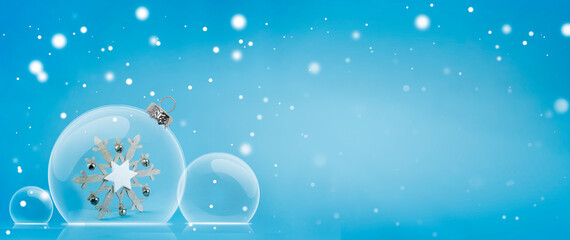 Christmas glass balls on a blue background with space for a copy. Beautiful holiday banner with white snowflakes on blue background. A large snowflake in a glass bead.