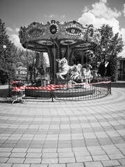 In the amusement park, the carousels do not operate; they are fenced off with warning tape.  There has been an accident.  The attraction is broken. - obrazy, fototapety, plakaty