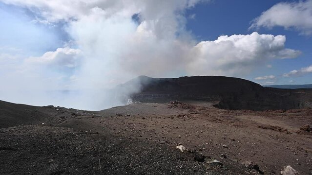 Cracked earth stone valley with smoke coming from volcano crater