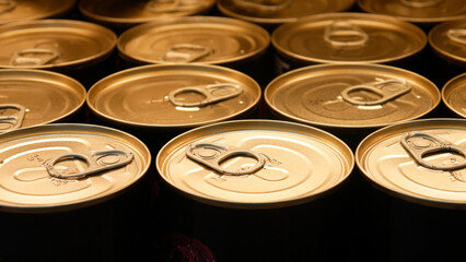 Close-up of many golden-black tins of canned food