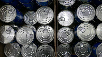 Many aluminum tins of canned food in trading boxes