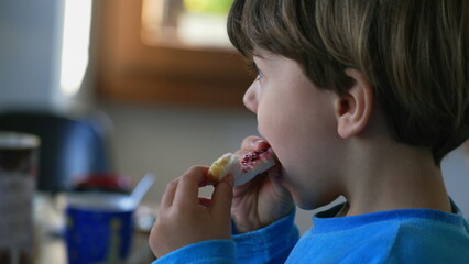 Close-Up Candid Moment - Child Relishing Morning Brioche with Jelly Spread