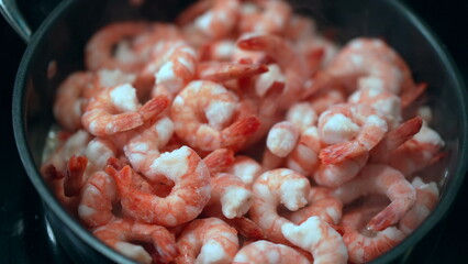 Cooking shrimps inside pan, preparing seafood. Healthy food concept