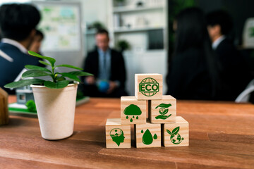ECO symbol on wooden cube arranged for alternative clean energy utilization and implementation in...