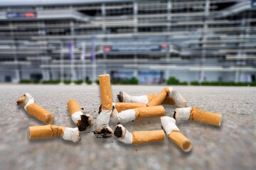 Cigarette butts lying on road asphalt. Trash