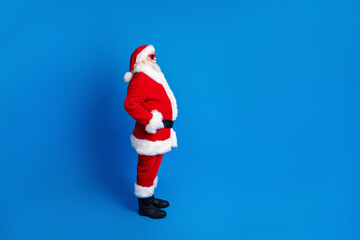Full body photo of retired old man touch belt profile view dressed stylish santa claus costume coat isolated on blue color background
