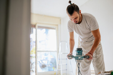 A worker is using manual cement mixer in a house and renovating.