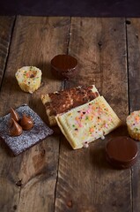 A close up of a tasty chocolate chip cookies, pancakes with frosting and a powdered sugar brownie