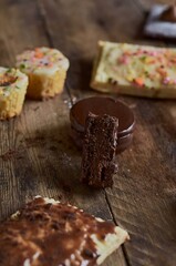 Close up of a tasty chocolate cake cut in half surrounded by muffins and cookies.