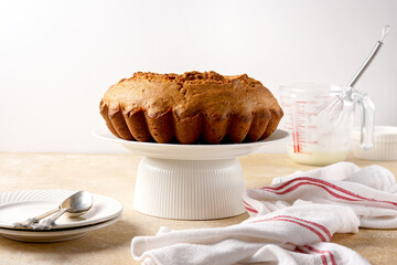 Pumpkin bundt cake ready for icing on a cake stand
