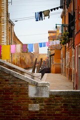 Colorful hang-out laundry in the typical narrow street of Venice, near the canal