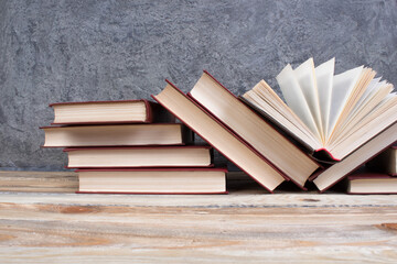 open book, books on the gray concrete background. Back to school. Education. Copy space for text.