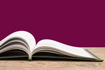 open book. Composition with hardback books, fanned pages on wooden deck table and red background. Books stacking. Back to school. Copy Space. Education background.