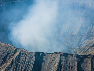 Aerial landscape view of the Bromo volcano crater with smoke coming. An active volcano in Tengger Semeru National Park in East Java, Indonesia.