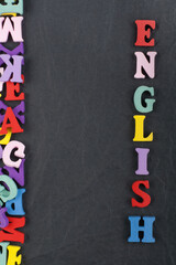 English word on black board background composed from colorful abc alphabet block wooden letters, copy space for ad text. Learning english concept.