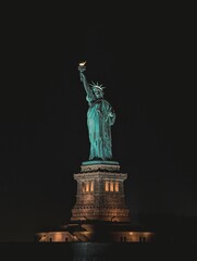 Beautiful view of a statue of liberty on a night sky background © Wirestock