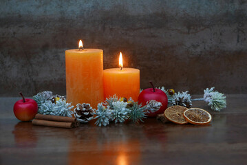 Orange candles with apple, orange slices and cinnamon sticks with space for text.