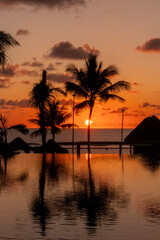 Fototapeta na wymiar Sunrise over the Gulf of Mexico reflected into the infinity pool at the resort