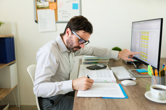 Public accountant with glasses doing taxes at the office