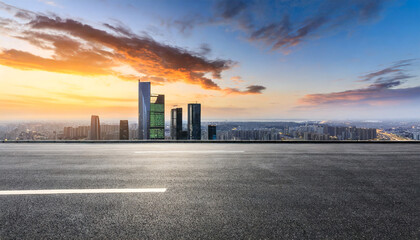asphalt road square and city skyline with modern buildings at sunset