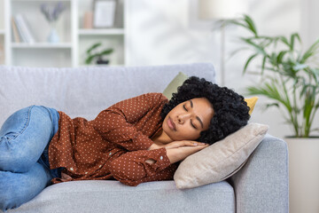 Young beautiful woman resting at home after work, African American woman sleeping napping on sofa...