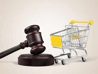 Shopping cart and wooden judge gavel on table