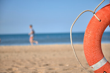lifebuoy on the background of the beach, the concept of saving people. Summer, orange lifeline