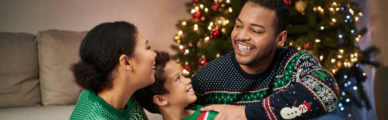 cheerful african american family sitting on floor and having great time together, Christmas, banner