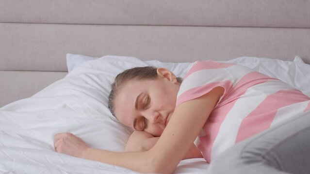 Upset depressed sick girl lying on bed in bedroom. Life crisis, insomnia, sleep disturbance.