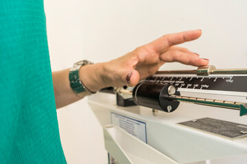 Close-up of woman on weighing scale in nutritionist's office.