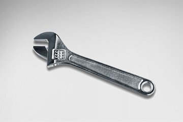 A steel shiny wrench on a light background.