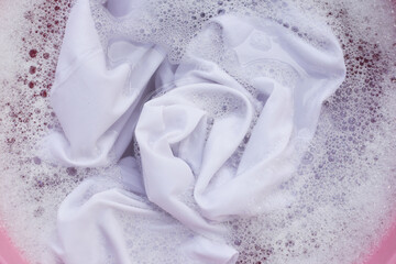 Laundry concept, white shirt soaking in water with detergent water dissolution, washing cloth