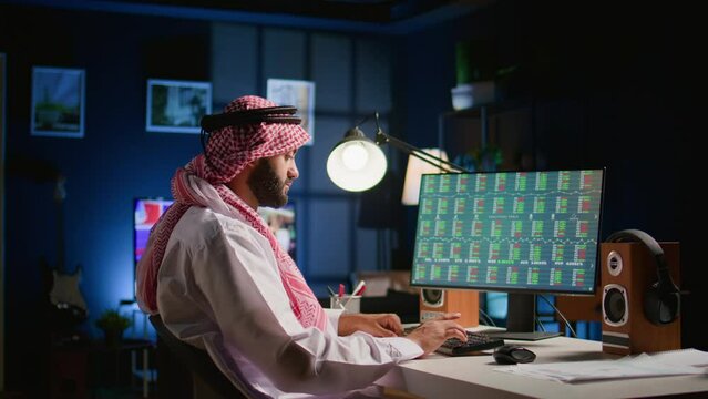 Muslim broker investor at personal office desk checking stock exchange valuation financial profit figures. Arab teleworking stockholder businessman looking at market shares growth, close up