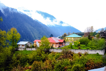 Amazing early morning view of a small colorful village below the mountain and cloudy sky at Sikkim,...