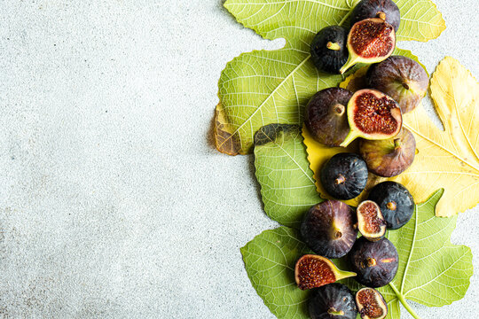 Overhead view of fresh organic figs on an arrangement of fig leaves