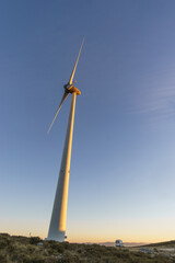 Wind turbines at Serra da Arada over mountain landscape in golden evening sunlight at sunset, Sao Pedro do Sul, Portugal