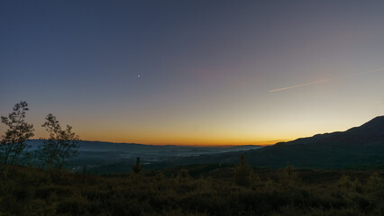 View from Serra da Arada over mountain landscape at evening twilight with crescent moon, Sao Pedro...