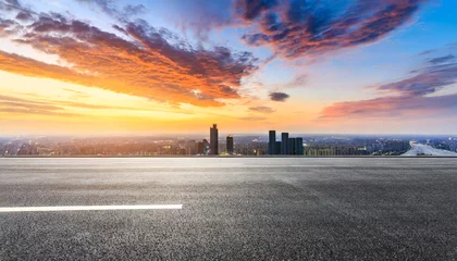 Poster asphalt road and city skyline with colorful sky clouds at sunset © Art_me2541