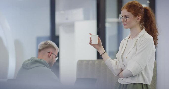 A modern businesswoman engages in a lively conversation with her colleagues while enjoying a coffee break in a contemporary office, exemplifying effective communication, teamwork, and work-life