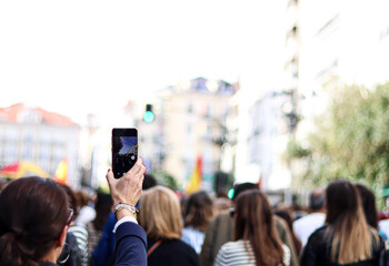 A woman at a demonstration recording with her mobile phone