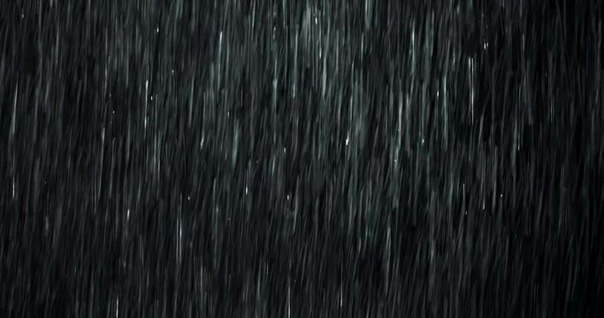 A heavy rain wall falls in front of the black screen in 4K loopable high-speed footage. Raindrops splashing. Rain closeup VFX insert. Practical, seamlessly loopable. Heavy rainstorm hitting black.