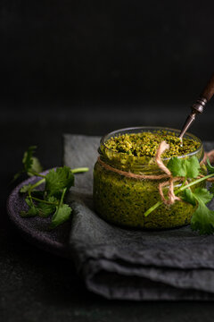 Close-up of a jar of traditional green Georgian adjika (Ajika) with coriander