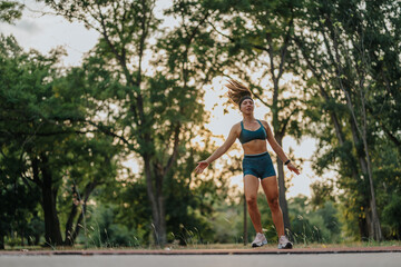 Obraz na płótnie Canvas Girl demonstrating impressive flexibility and strength with 360-degree cartwheels in a green park.