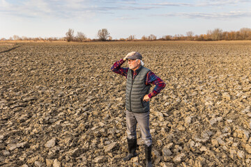 Farmer looking at dry soil in field