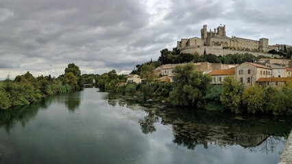 Fototapeta na wymiar Drone shot of the Cathedral of St. Nazarius on the bank of a river in Beziers, France