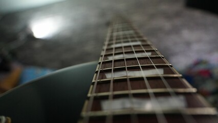 Closeup shot of guitar strings in a room with blurry background