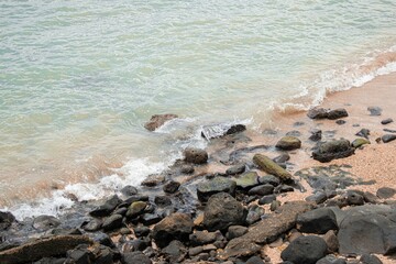 Fototapeta na wymiar Closeup view of a rocky coastline with a calm sea waves