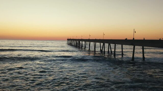 Pier in the pacific ocean at sunset 